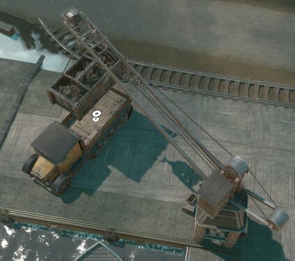 A Stationary Crane placing a Resource Container on a Flatbed Truck.